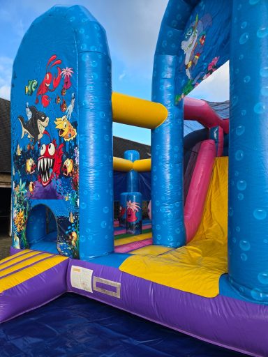 Château gonflable coloré avec des personnages marins et un toboggan. Château gonflable coloré avec des personnages marins et un toboggan.
